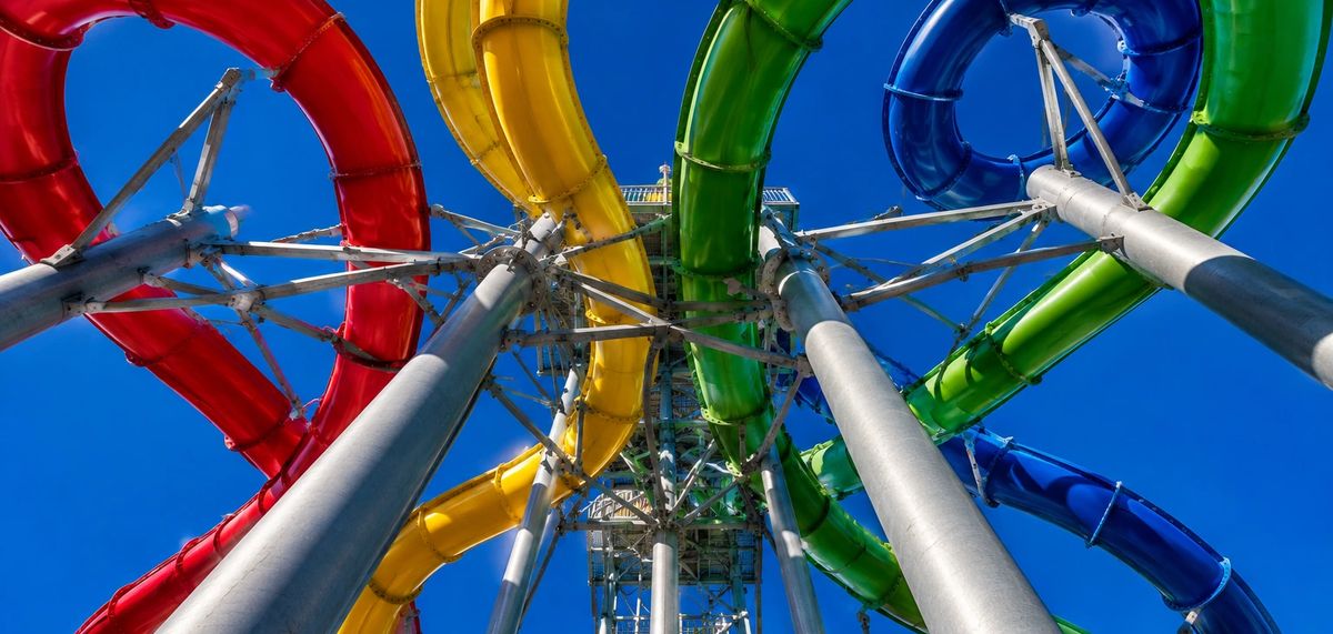 Looking up at four commercial water slide flumes spiralling from a steel tower