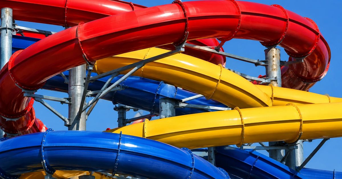 Interlocking red, yellow and blue commercial water slide flumes against a clear sky